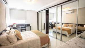 Ein Hotelzimmer mit Bett, Schreibtisch und einer Schiebetür, die auf einen Balkon führt.