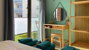 Une chambre d’hôtel avec un lit, un bureau, une chaise et une vue sur un balcon.