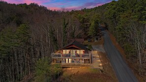 A lodge with a deck and a road leading to it, surrounded by forest. - 10 Min from Dollywood! 2 Fireplaces •Private Hot tub• Amazing Mtn Views! (Sevierville)