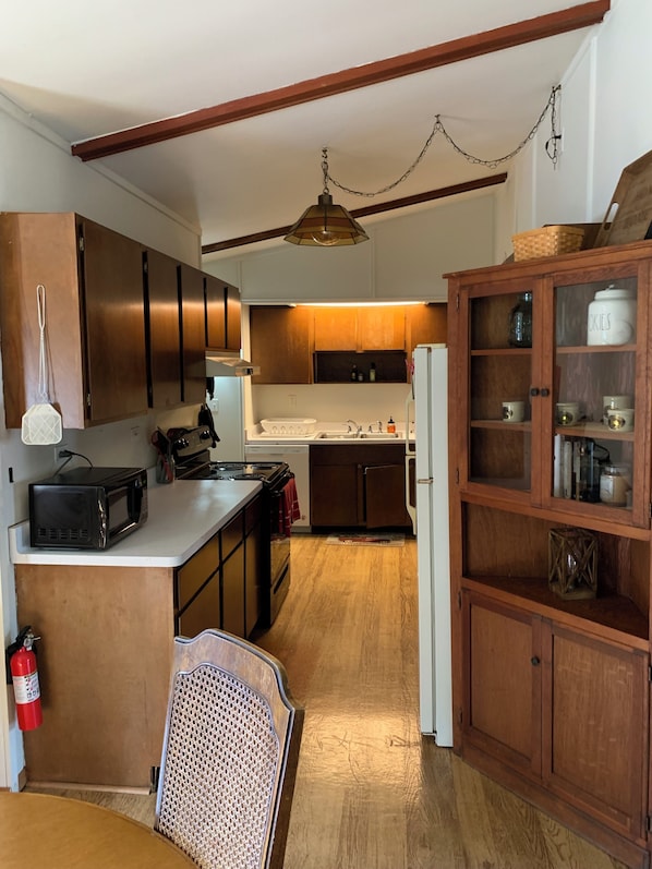 A kitchen with wooden cabinets, a microwave, a stove, and a refrigerator.