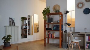 A well-lit room with a wooden desk, chair, and shelves with books and decorative items. - Cozy apartment with private terrace in Kalsa, in the heart of Palermo (Palermo)