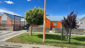 Zona residencial con casas, un coche y un árbol.