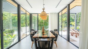 Un comedor moderno con una mesa grande, sillas negras y una lámpara colgante.