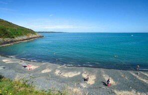 A beach with clear blue water, rocky shore, and people sunbathing. - Spacious 3-Bedroom Apartment in Guingamp, 6 Guests (Guingamp)
