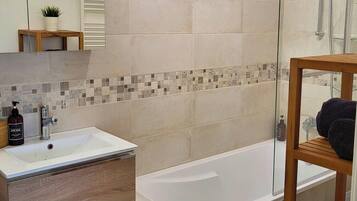 Une salle de bain moderne avec un lavabo rectangulaire, un meuble-lavabo en bois et une baignoire sur pieds.