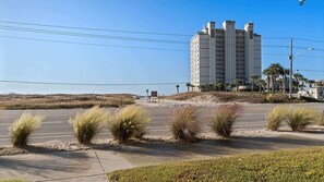 A coastal hotel with a modern design, featuring a prominent central tower and multiple balconies.