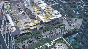Ein Hochhaus mit Dachgarten, der Sonnenblumen und einen Swimmingpool zeigt.