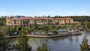 Een resort met meerdere gebouwen, een centraal zwembad en een omliggende waterpartij.