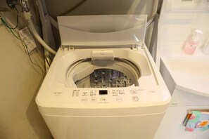 Eine Waschmaschine mit Frontöffnung, einer Bedienkonsole, einer transparenten Tür und einem weißen Gehäuse.