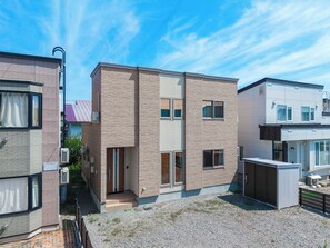 A modern residential building with a brick facade, multiple windows, and a small entrance. - THE VERTEX / Asahikawa City Hokkaidō (Asahikawa City)