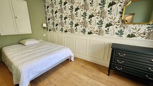 Ein Schlafzimmer mit einem Bett, einem Schminktisch und einem blumigen Wanddesign.