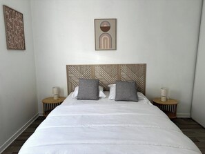A neatly made bed with two pillows, a wooden headboard, and two bedside tables with lamps. - Escapade fécampoise - On the heights of Fécamp (Fécamp)