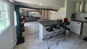 A modern kitchen with a central island, a dishwasher, and a dining area with a sofa and chairs. - Old-fashioned charm with modern comforts (Doudeville)