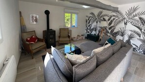 A living room with a sofa, chairs, a coffee table, and a fireplace. - Old-fashioned charm with modern comforts (Doudeville)