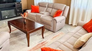 Un soggiorno con un divano modulare color beige, un tavolino in legno e un camino.