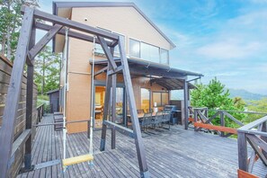 Une maison moderne dotée d’une terrasse, de mobilier d’extérieur et offrant une vue sur les montagnes.
