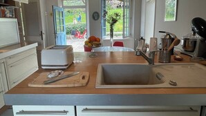 Una cocina con una isla central, un tostador, un fregadero y una ventana con vistas al exterior.