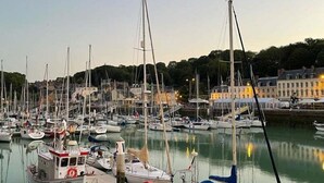 Una marina con varios barcos amarrados, un muelle y edificios al fondo.