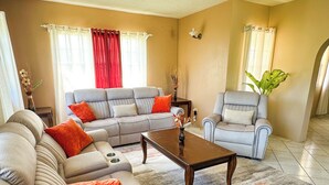 Una sala de estar con un sofá gris, una mesa de centro de madera y un sillón gris.