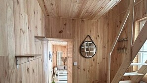 A wooden interior with a kitchen area, a staircase, and a view into another room. - Wooden duplex and sea in Fécamp, sea 50 m away (Fécamp)