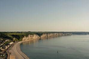 A coastal town with a curved beach, cliffs, and a calm sea. - Wood & sea duplex · Beach 50 m · For 2 (Fécamp)