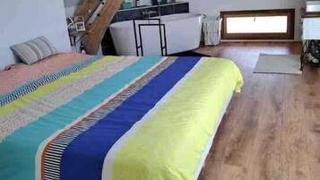 Un dormitorio con cama, escritorio y ventana.