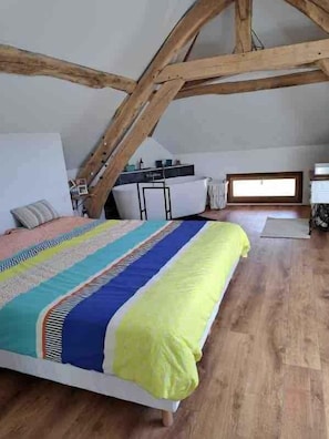 Un dormitorio con cama, escritorio y ventana.