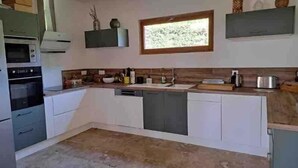 A kitchen with built-in appliances, a window, and a wooden countertop. - L'Écho de la Nature | Norman Farm • 1ha • Near Veules & Étretat (Sasseville)