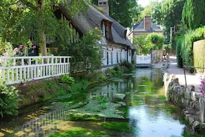 Un canal étroit, bordé d’immeubles d’un côté, d’une clôture blanche et d’un mur de pierre de l’autre.