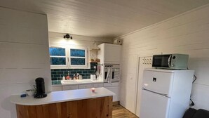 A compact kitchen with a wooden island, white appliances, and a window. - Anchoring, cottage near the sea (Sotteville-sur-Mer)