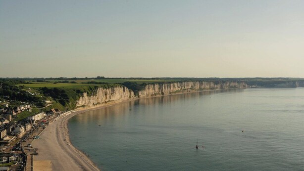 Une ville côtière dotée d’une baie en forme de croissant, de falaises et d’une plage.