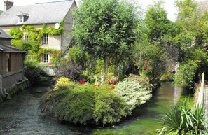 Ein schmaler Kanal, gesäumt von üppiger Vegetation und traditionellen Steinbauten.