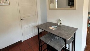 A small dining area with a table and bench, a white door, and a large mirror on the wall. - Idyllic Normandy stay (Veules-les-Roses)
