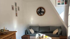 A cozy living room with a grey sofa, wooden cabinet, and a round coffee table. - Idyllic Normandy stay (Veules-les-Roses)