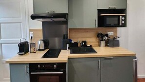 A compact kitchen with a built-in oven, microwave, and a stovetop. - Idyllic Normandy stay (Veules-les-Roses)