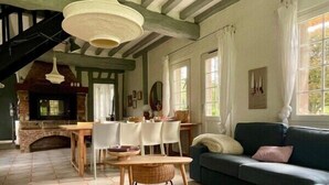 A spacious living room with a fireplace, a dining area, and a sofa.