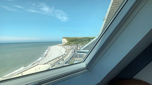 A view from a window overlooking a beach with a road and buildings in the distance. - Apartment with superb sea and land views (Veulettes-sur-Mer)