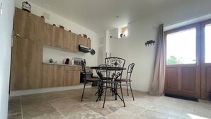 Une cuisine avec des meubles en bois, une table à manger avec des chaises et une grande fenêtre donnant sur un beau paysage.