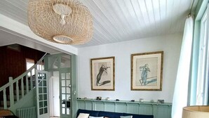 Un salon comprenant un canapé, un fauteuil, une table basse et un luminaire suspendu.