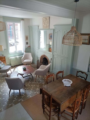 Un comedor con mesa y sillas de madera, chimenea y muebles de cocina azul claro.