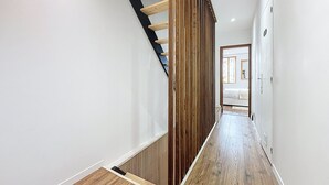 Ein modernes Interieur mit einer Holztreppe, weißen Wänden und Holzboden.