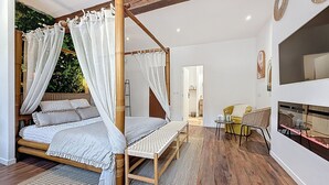 Ein geräumiges Schlafzimmer mit einem großen Bett, einem kleinen Tisch und einer Sitzecke.