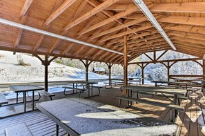 A covered picnic area with wooden benches and tables, surrounded by snow-covered ground and trees. - Mtn-View Gem w/ Hot Tub + Game Room in Sevierville (Sevierville)