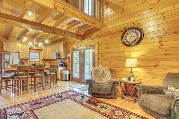 A spacious wooden cabin interior with a dining area, a cozy seating area, and a kitchen. - Mtn-View Gem w/ Hot Tub + Game Room in Sevierville (Sevierville)