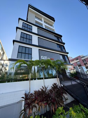 Um edifício moderno de vários andares com uma placa que diz 'GET BY SIDE'.