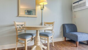 A room with a round table, two chairs, a lamp, a mirror, and an air conditioning unit. - Ocean-View Balcony! Couples Escape in Myrtle Beach (Myrtle Beach)
