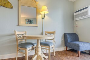 A room with a round table, two chairs, a lamp, a mirror, and an air conditioning unit. - Ocean-View Balcony! Couples Escape in Myrtle Beach (Myrtle Beach)