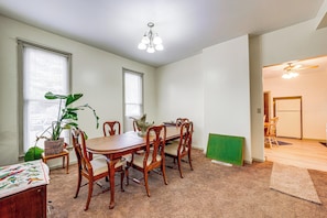 A dining area with a wooden table and chairs, a potted plant, and a ceiling light fixture. - Walk to Old Town Ottawa! Starved Rock Country Home (Ottawa)