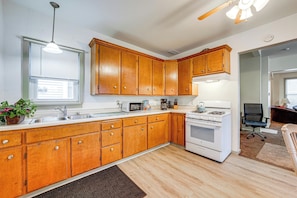 A kitchen with wooden cabinets, a microwave, a stove, and a sink. - Walk to Old Town Ottawa! Starved Rock Country Home (Ottawa)