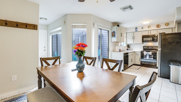 A kitchen with white cabinets, a microwave, an oven, and a refrigerator.